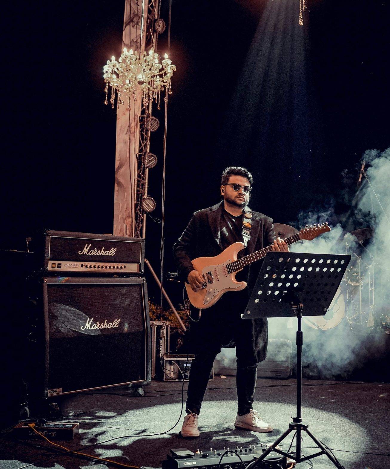 Elvis Mark Gabriel with a Marshall stack under a chandelier