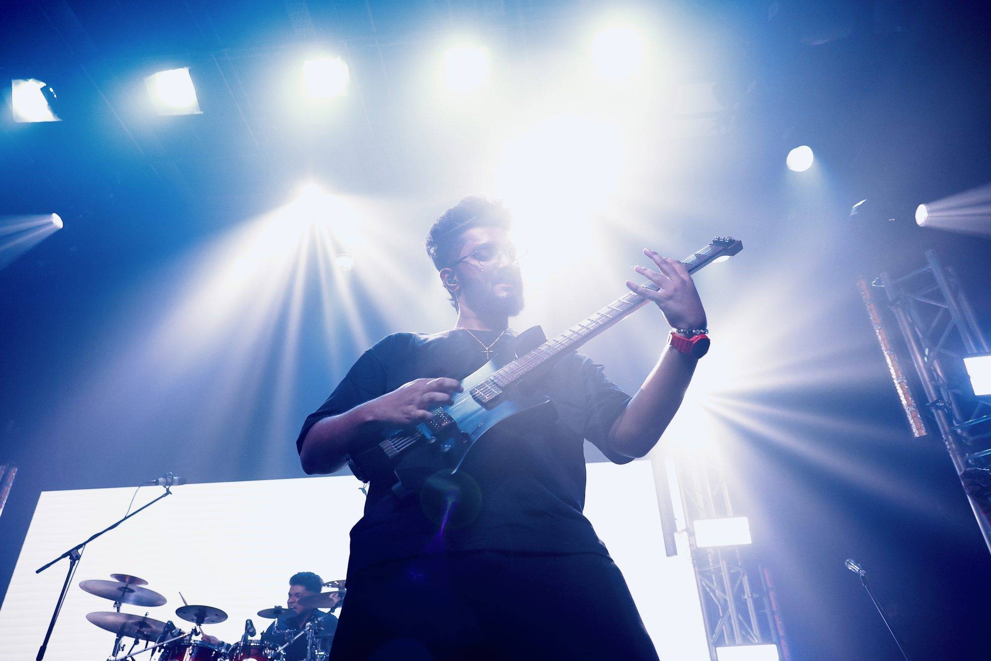 Ezekiel Bernard performing under blue stage lights
