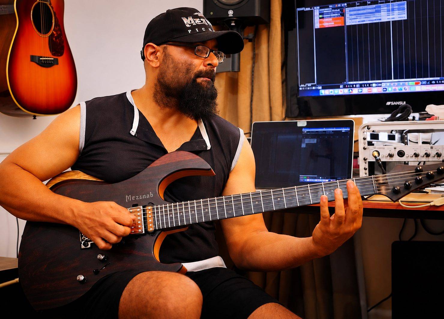 Abraar playing a Mezraab guitar in his studio