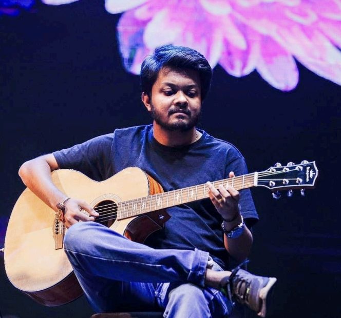 Abhishekh Prabhu playing guitar on stage