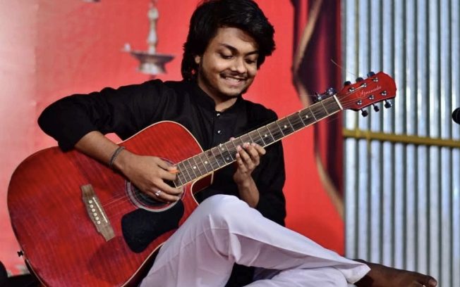 Abhishekh Prabhu playing acoustic guitar