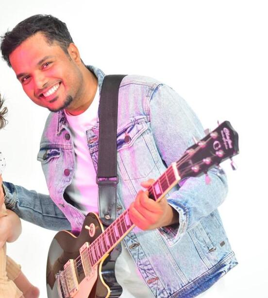 Stephen G Emmanuel smiling with his guitar