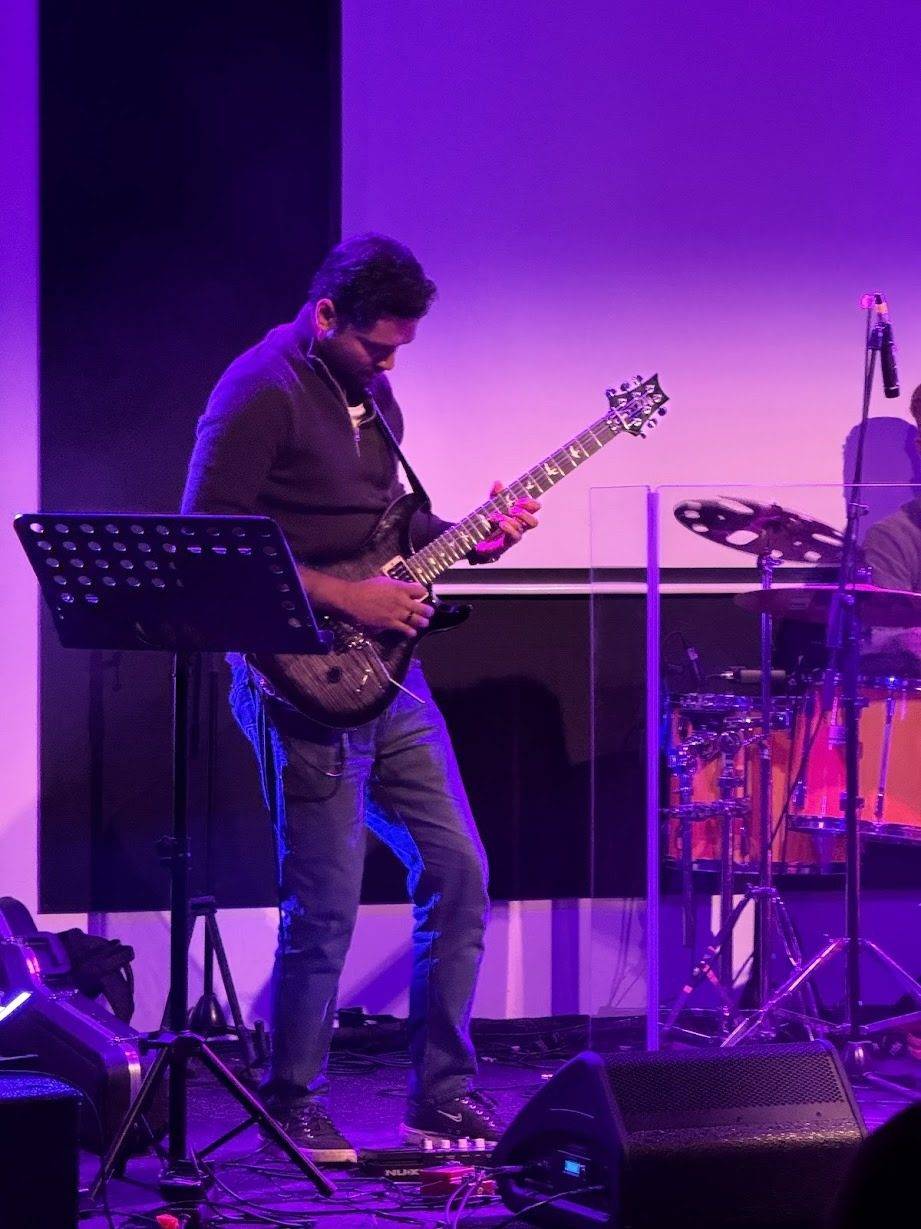 Stephen G Emmanuel performing under purple lights