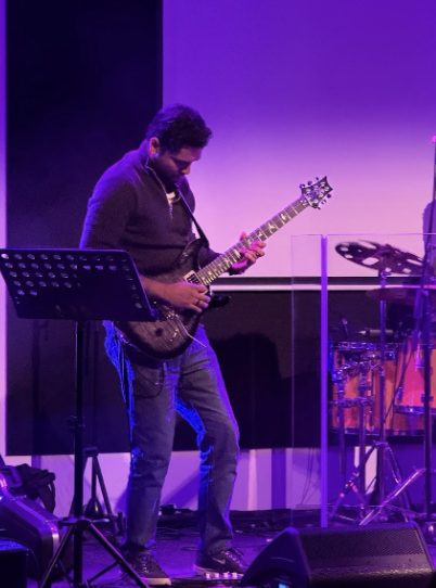 Stephen G Emmanuel performing on stage under purple lights