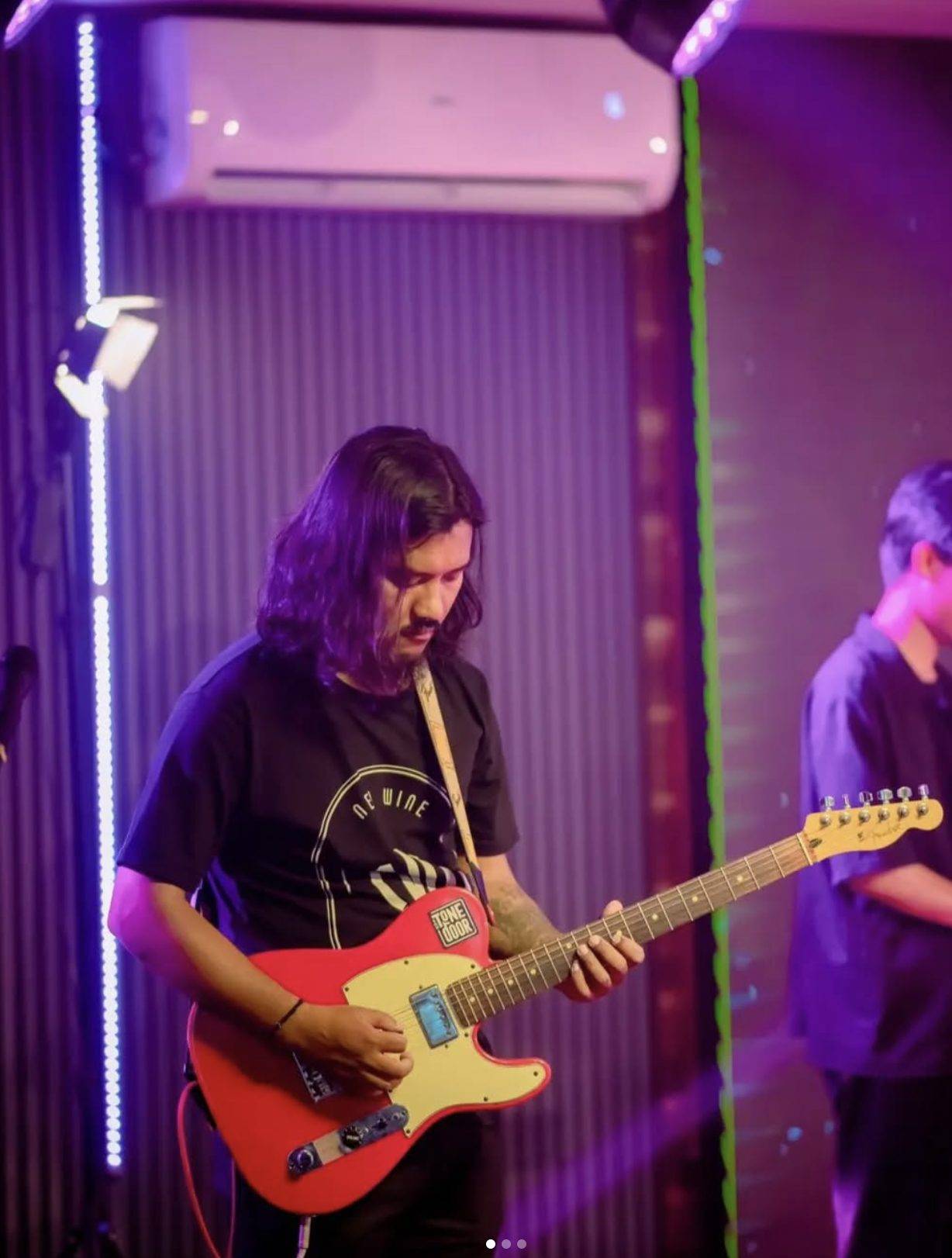 Temjen Longkumer playing under purple stage lights