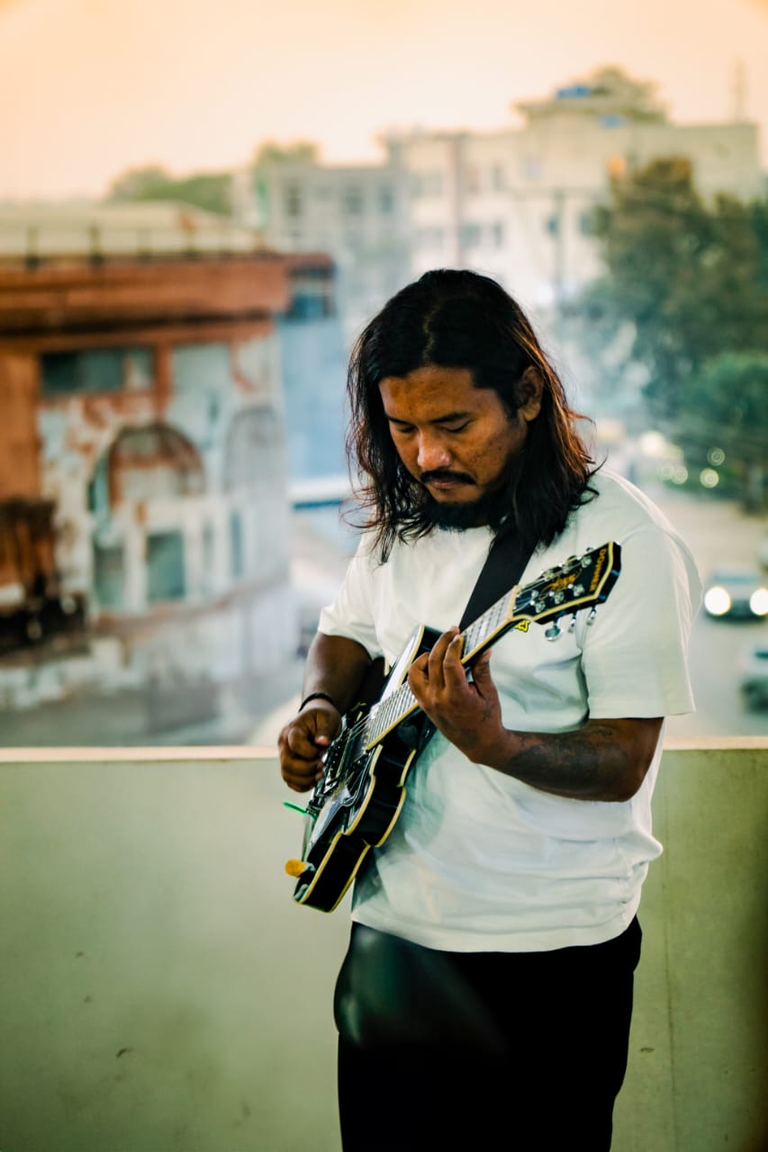 Temjen Longkumer playing on a rooftop at sunset